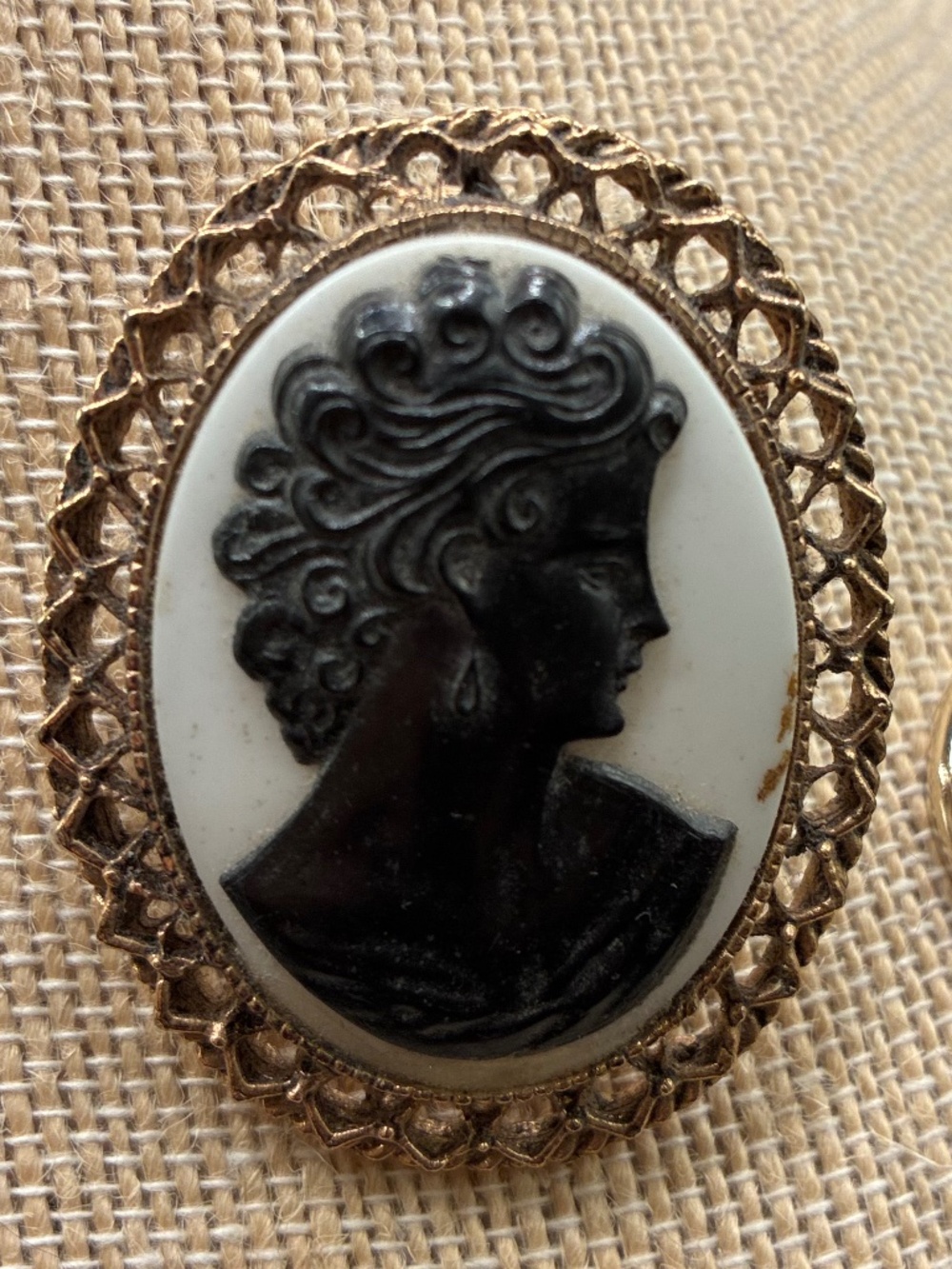 vintage cameo brooch with black profile of a woman’s face on ivory